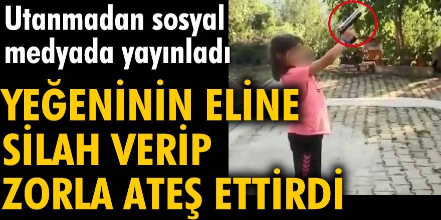 Yeğeninin eline silah verip zorla ateş ettirdi. Utanmadan sosyal medyada yayınladı