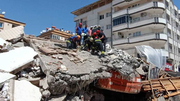 Deprem bölgesinde ağır hasarlı bina çöktü; iş makinesi operatörü enkaz altında kaldı