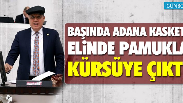 Ayhan Barut başında Adana kasketi, elinde pamukla kürsüye çıktı