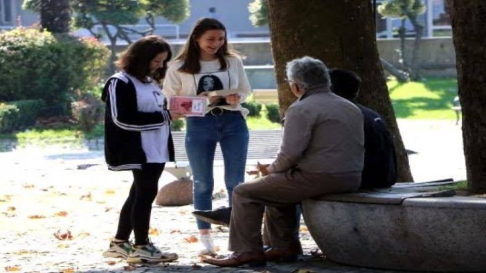 Lise öğrencileri parkta oturan halka ücretsiz kitap dağıttı